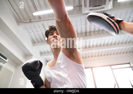 Beau monter hispanic man in boxing gym avec rival méconnaissable Banque D'Images