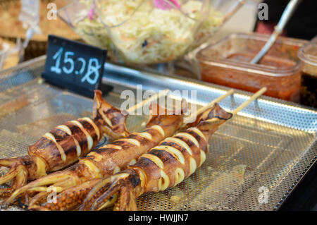 Barbecue brochettes de calmars vendus à partir de la cale à un marché de l'alimentation de rue près de Central World mall à Bangkok, Thaïlande Banque D'Images