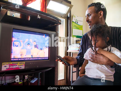 Le pasteur Mohamed Ousman Salih qui converti de l'islam au christianisme en regardant une chaîne de télévision religieuse avec sa fille, Addis-Abeba région, Banque D'Images