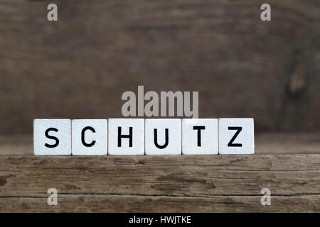 Mot allemand, la protection de l'écrit en cubes on a wooden background Banque D'Images