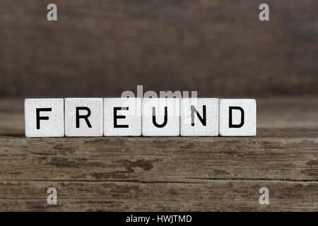 Mot allemand ami, écrit en cubes on a wooden background Banque D'Images