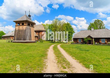 Chemin Rural à Tokarnia village avec ancienne église en bois aux beaux jours du printemps, Pologne Banque D'Images