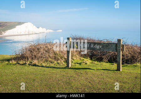 Avertissement signe de falaise à Seaford Head Nature Reserve, East Sussex, avec les Sept Soeurs falaises dans l'arrière-plan Banque D'Images