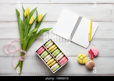 Espace de travail féminin avec ses macarons et tulipes Banque D'Images