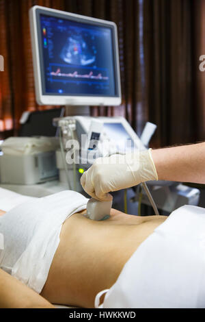 Médecin dans un hôpital salle de diagnostic faire une échographie de l'abdomen d'un patient avec sonde convexe. Équipement médical moderne, preventional médecine et h Banque D'Images