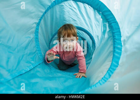 Petit enfant jouant dans un tunnel tube, ramper dans elle et d'avoir du plaisir. Plaisir en famille, l'éducation précoce et de l'apprentissage par l'expérience concept. Banque D'Images