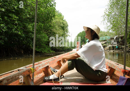 Traveller femme thaïlandaise s'asseoir sur le service de bateau longue queue à la vue de voyage et rivière et forêt de mangroves intertidales ou sur la forêt de la rivière Nam Pak Banque D'Images