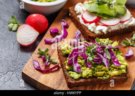 Toasts avec du fromage à la crème, le radis et l'avocat et à l'avocat et du chou rouge Banque D'Images