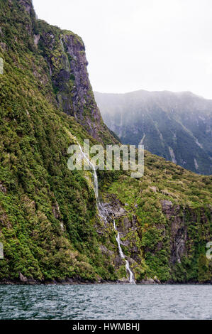 Cascade d'eau douce sous un ciel couvert et journée pluvieuse dans le Milford Sound, sur l'île du sud de la Nouvelle-Zélande Banque D'Images