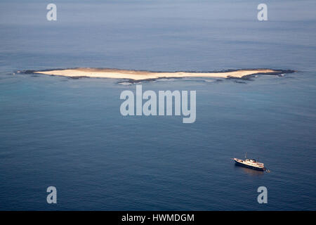 Bateau ancré près de l'îlot de Mosquera dans les îles Galapagos. Cette petite île plate inhabitée a été créée par le soulèvement géologique de lave sous-marine. Banque D'Images