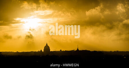 Coucher du soleil doré avec des nuages sur la ville de Rome, Italie. La silhouette de la Basilique St Pierre (Basilique Papale di San Pietro in Vaticano) est vu sur Banque D'Images