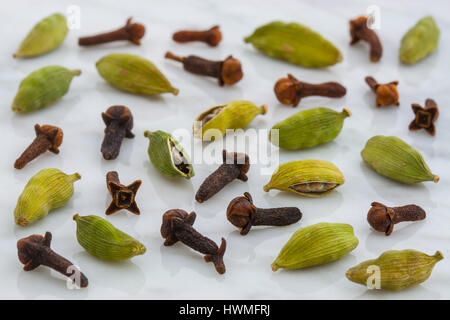 Belles gousses de cardamome et de girofle sur le dessus de marbre de Carrara et coutertop Banque D'Images