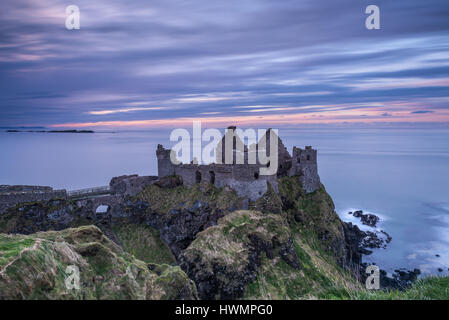 Coucher de soleil au château de Dunluce sur la côte nord de l'Irlande Banque D'Images