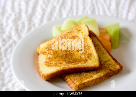 Deux tranches de pain doré placé au melon à l'horizontale et photographie. Brown, délicieux petit-déjeuner sain avec de miellat et de cantaloup et de copier l'espace. Banque D'Images