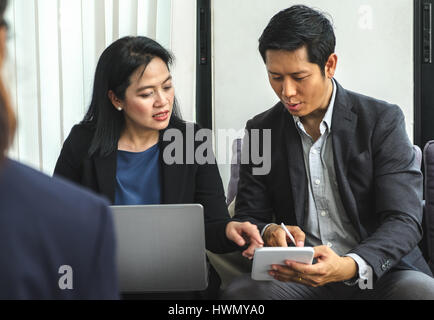 La femme et l'homme d'affaires à l'aide de tablet pc portable de travail,rabotage à réunion d'entreprise dans office,Business conference concept. Banque D'Images