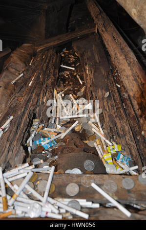 Coins et les cigarettes éparpillés sur un cercueil brisé à Londa Sépulture dans Tana Toraja, au sud de Sulawesi, Indonésie. Banque D'Images