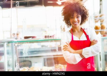 L'image graphique de flare contre jolie employee posing with arms crossed Banque D'Images