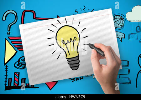 Main tenant crayon noir contre fond bleu Banque D'Images