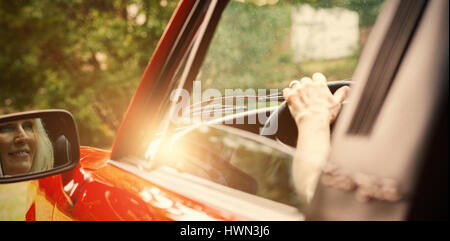 Cheerful mature woman driving convertible sur sunny day Banque D'Images