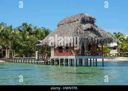 Bungalow sur pilotis avec toit de chaume, l'île de Bastimentos, Bocas del Toro, Panama, des Caraïbes Banque D'Images