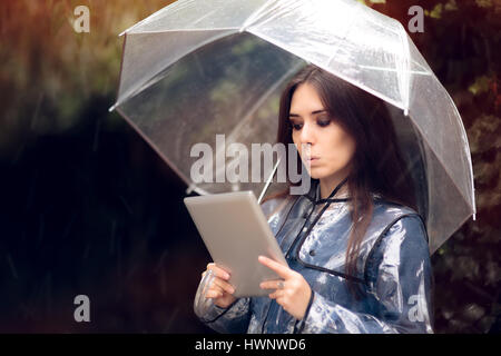 Surpris Femme en imperméable avec parapluie Transparent Banque D'Images