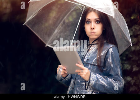 Surpris Femme en imperméable avec parapluie Transparent Banque D'Images