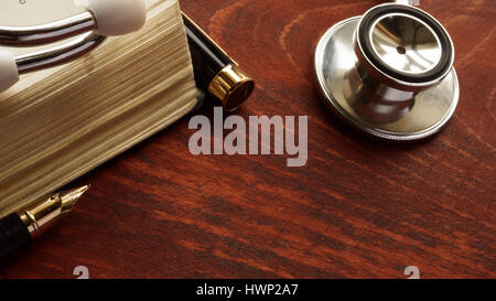 Concept de soins médicaux. Stéthoscope et livre sur une table. Banque D'Images