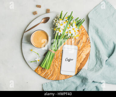 Tasse de café du matin, le godet de fleurs et d'un téléphone mobile Banque D'Images