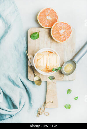 Sorbet pamplemousse rose avec des feuilles de menthe fraîche sur planche de bois Banque D'Images