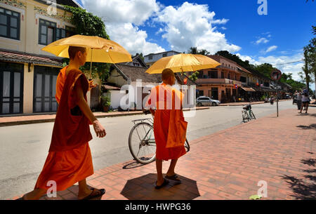 Loungprabang, Laos - Août 7, 2015 : peu de non identifiés 2 moines se balade dans la rue avec sun protection parapluie. Banque D'Images