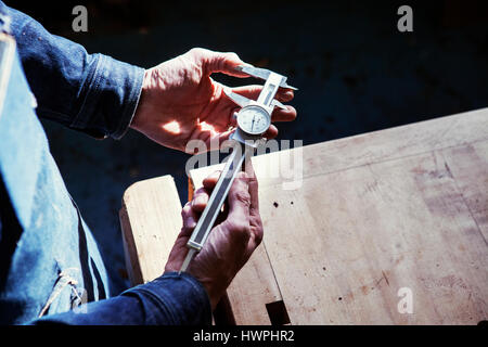 Portrait carpenter holding vernier à table dans l'atelier Banque D'Images