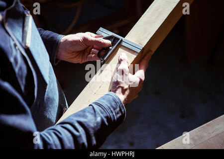 Portrait carpenter measuring planche en bois dans l'atelier Banque D'Images