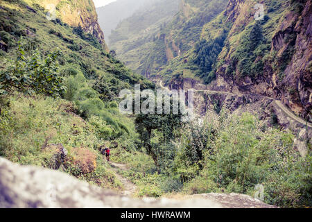 Femme Sac à dos escalade avec backpacker dans l'Himalaya, au Népal. Le trekking et la randonnée avec sac à dos en haute montagne. Annapurna Himal Range sur l'Annapurna Banque D'Images