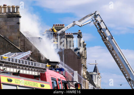 Service d'incendie et de sauvetage écossais les pompiers sur une échelle la lutte contre un feu de bâtiment. Elie et de Earlsferry, Fife, Scotland, UK, Grande-Bretagne, Europe Banque D'Images