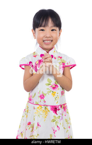 Little girl wearing chinois asiatique avec des gestes d'accueil cheongsam qui souhaitent tout le monde heureux nouvel an chinois à fond blanc isolé. Banque D'Images