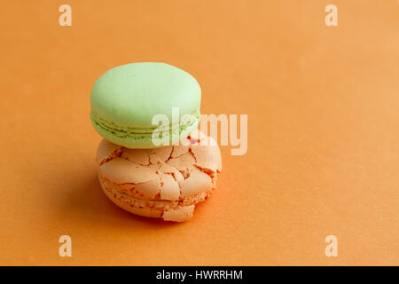 Macarons orange et vert sur fond orange with copy space Banque D'Images