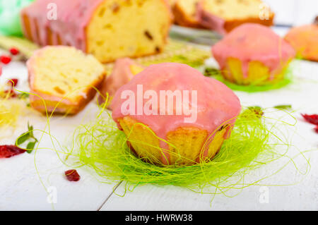 Gâteau de fête douce avec des raisins secs et des canneberges séchées, décoré avec du sucre glace sur un fond clair. Banque D'Images