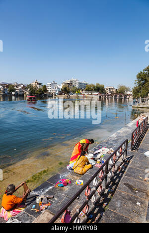 Les femmes indiennes locales faisant leurs étapes de lavage sur la rive du lac Pichola, Udaipur, l'état indien du Rajasthan. Banque D'Images