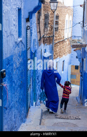 Chefchaouen, Maroc. Mère et fille marchant dans une rue étroite. Banque D'Images