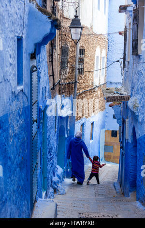 Chefchaouen, Maroc. Mère et fille marchant dans une rue étroite. Banque D'Images