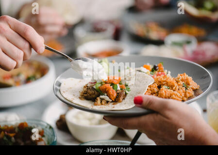 Les mains coupées des amis Faire de taco à table à manger Banque D'Images