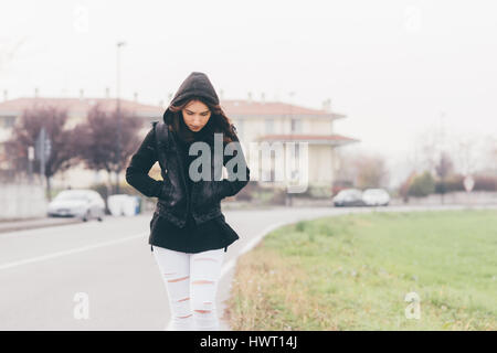 Belle jeune femme de l'est à l'extérieur de marche dans la ville port hoodie - marche à pied, la marche, le concept d'automne Banque D'Images