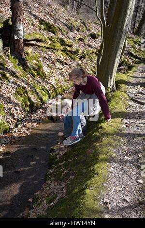 Deux enfants jouent dans un petit ruisseau dans le bois Banque D'Images