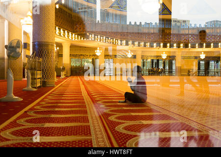 Un homme prie dans la salle de prière à Masjid Negara, Kuala Lumpur, Malaisie Banque D'Images