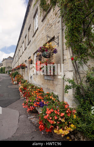 Affichage de superbes plantes, fleurs, pots, boîtes et paniers suspendus veuve décorer une terrasse en pierre de Cotswold de maisons à Cecily HIll à Cirencester Banque D'Images