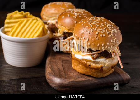 Mini-Hamburgers faits maison avec salade de chou sur la Petite Planche à découper en bois. Sandwiches de viande barbecue sur table rustique. Banque D'Images