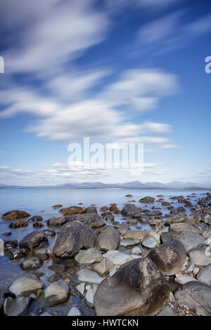 Une longue exposition libre de nuages et de rivages rocheux sur une plage près de Harlech, dans le Nord du Pays de Galles Banque D'Images