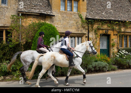 L'équitation à travers le village de Cotswold de Stanton, Gloucestershire, Angleterre Banque D'Images