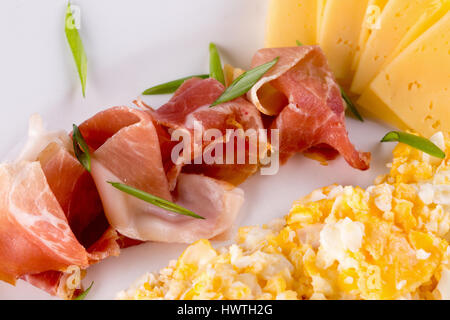 Rouleau d'omelette avec fromage et jambon tranches sur la plaque. Banque D'Images