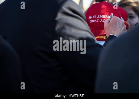 Président américain Donald Trump signe un hat pour un greeter après son arrivée à l'Aéroport International de Palm Beach le 3 février 2017 à Palm Beach, en Floride. Banque D'Images